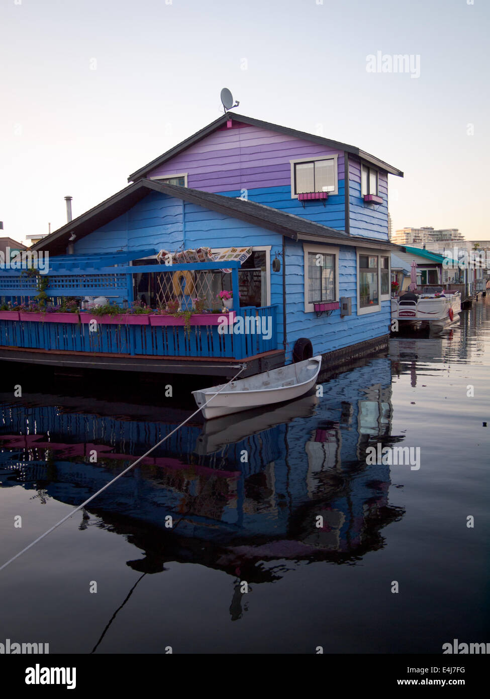 Una vista di coloratissimi houseboat galleggiante (home) e canoa ormeggiata al Pontile del Pescatore in Victoria, British Columbia, Canada. Foto Stock