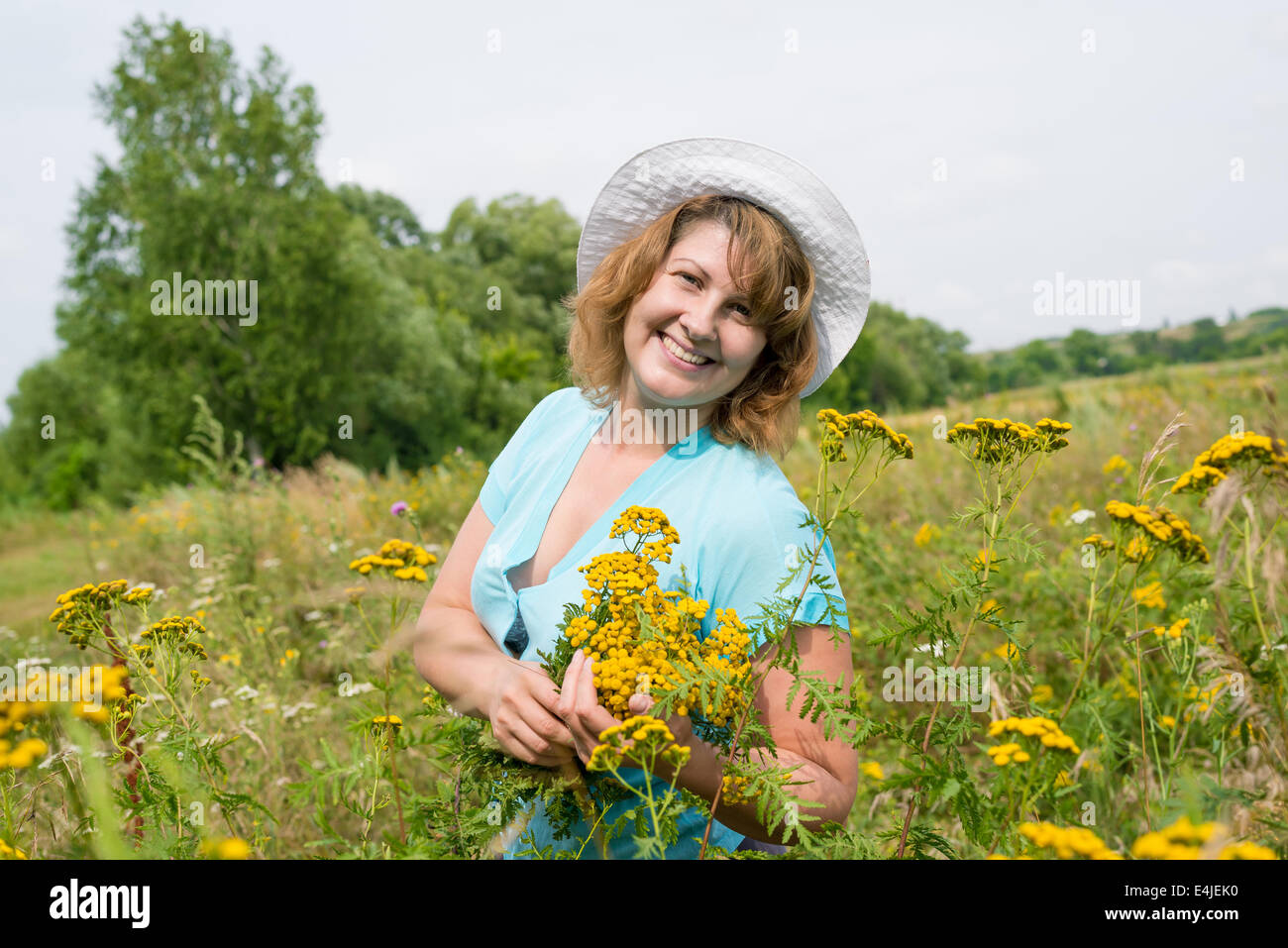 Donna di mezza età su un prato con tansy Foto Stock