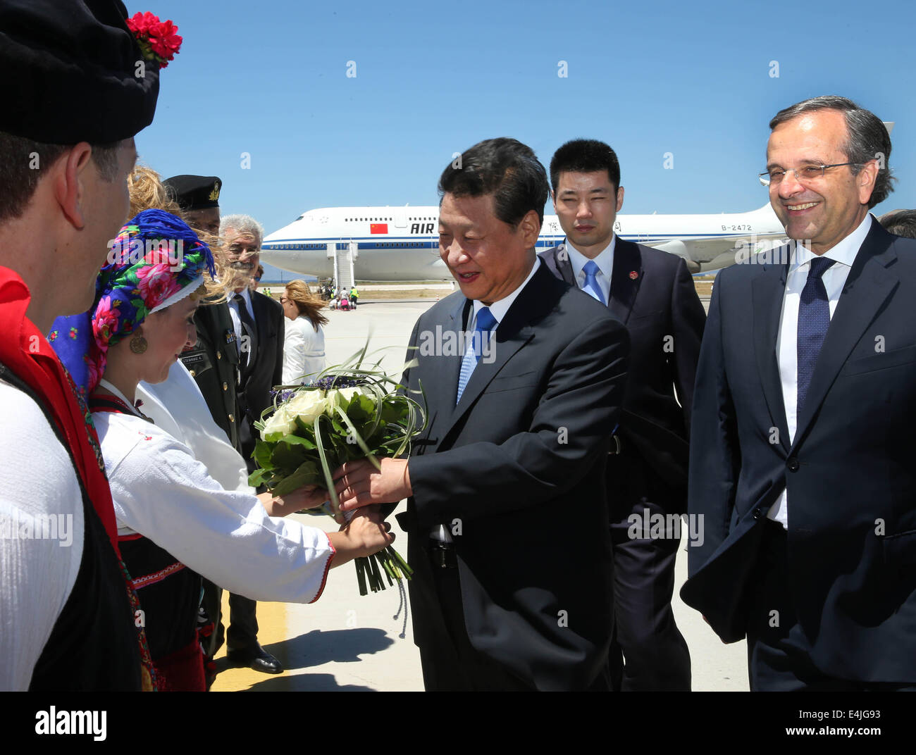 L' isola di Rodi, Diagoras International Airport sulla isola di Rodi in Grecia. 13 Luglio, 2014. Il presidente cinese Xi Jinping (C), che è accompagnato dal Primo Ministro greco Antonis SAMARAS (1R), riceve un mazzo presentato dalla gioventù locale dopo essere arrivati presso l'aeroporto internazionale di Diagoras in Rodi in Grecia, 13 luglio 2014. Xi Jinping sono arrivati in Grecia la domenica per fare una sosta durante il suo modo di America Latina, dove egli pagherà le visite di stato in Brasile, Argentina, Venezuela e Cuba, nonché assistere al sesto vertice BRICS. Credit: Lan Hongguang/Xinhua/Alamy Live News Foto Stock