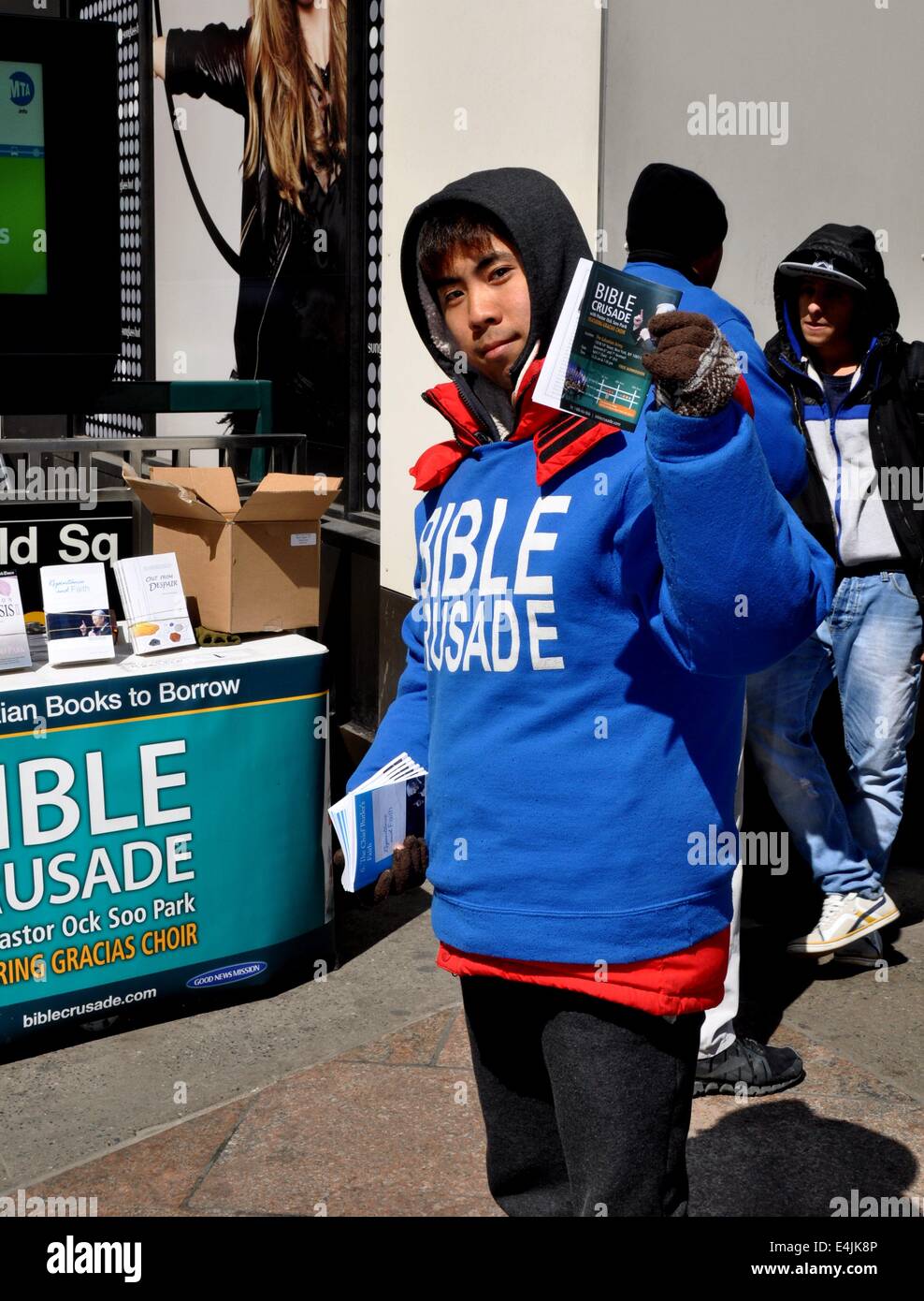 NYC: giovane uomo asiatico distribuire volantini religiosa durante una Bibbia crociata su West 34th Street e Broadway Foto Stock