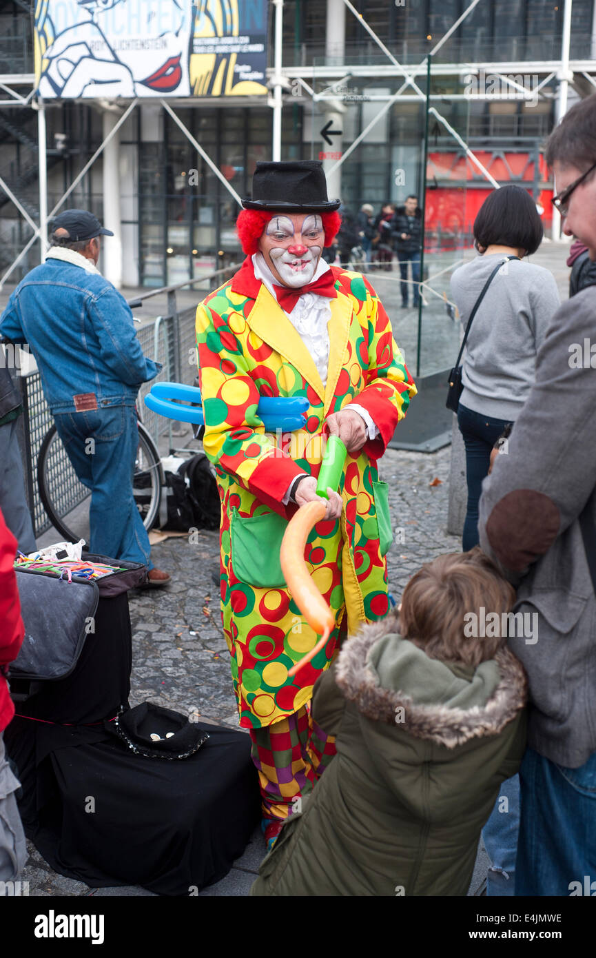 Parigi, Francia - Clown nella zona Pompidou rendendo i modelli di palloncino per i bambini Foto Stock