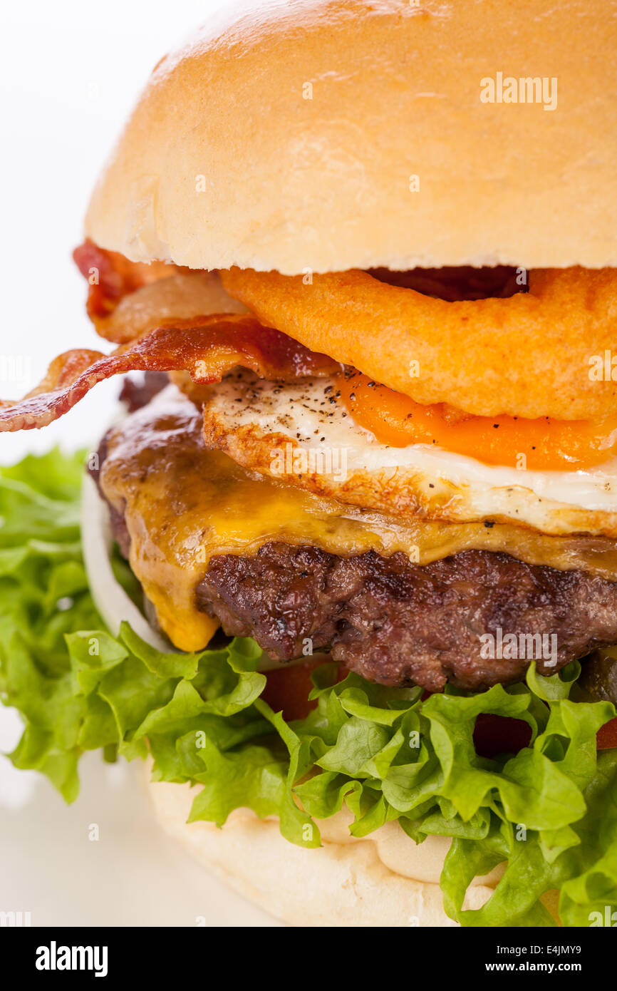 Deliziose uova e bacon cheeseburger con un riempimento nutrizionale di insalata ingredienti, una polpetta di carne macinata, formaggio, uova fritte e Foto Stock