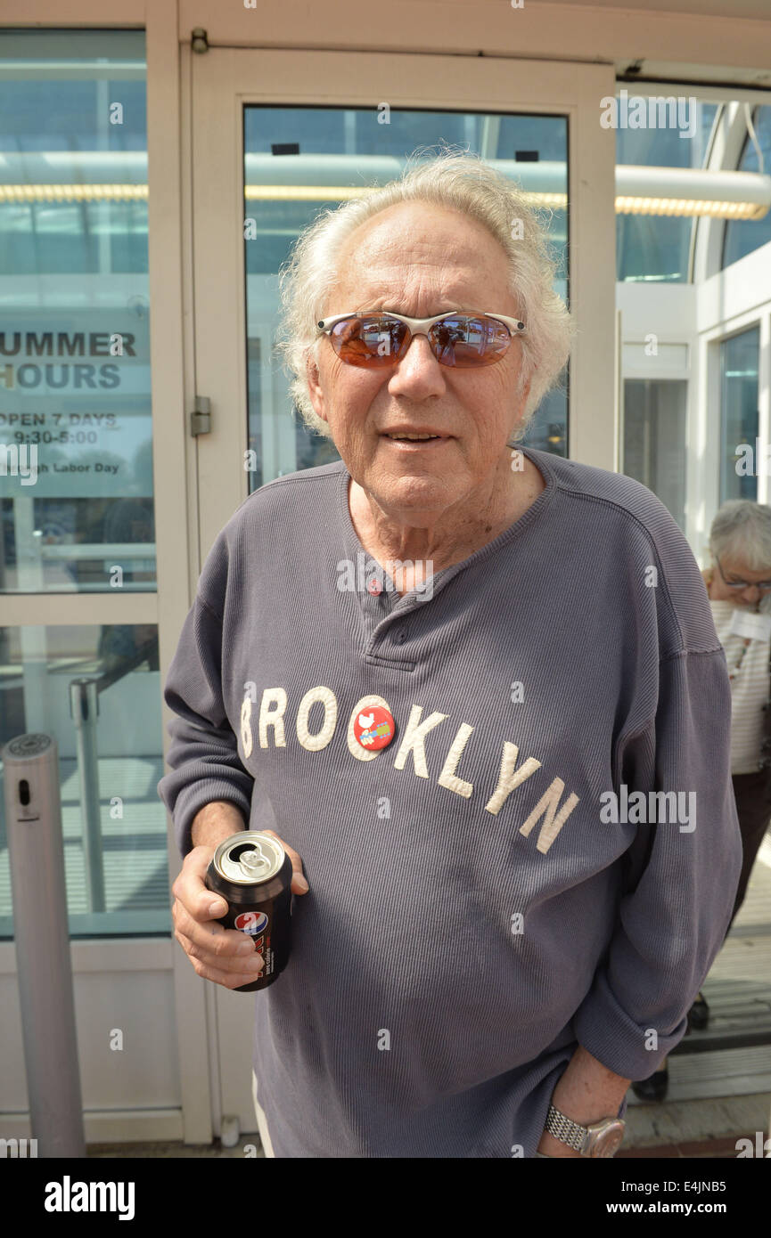 Città Giardino, New York, Stati Uniti d'America. 12 Luglio, 2014. ARTIE KORNFELD, Festival di Woodstock organizzatore, è alla base del Museo dell'aviazione per aiutare kick-off la loro estate del '69 Celebrazione presentano, su il quarantacinquesimo anniversario della leggendaria Agosto 1969 Woodstock Music & Art Fair in Upstate New York. Kornfeld, che è cresciuto a Long Island, è un compositore, manager, produttore, publisher e promotore e indossa un perno con iconico Woodstock logo della colomba su un collo di chitarra, imperniata sulla lettera o di Brooklyn, dove era nato. © Ann Parry/ZUMA filo/Alamy Live News Foto Stock