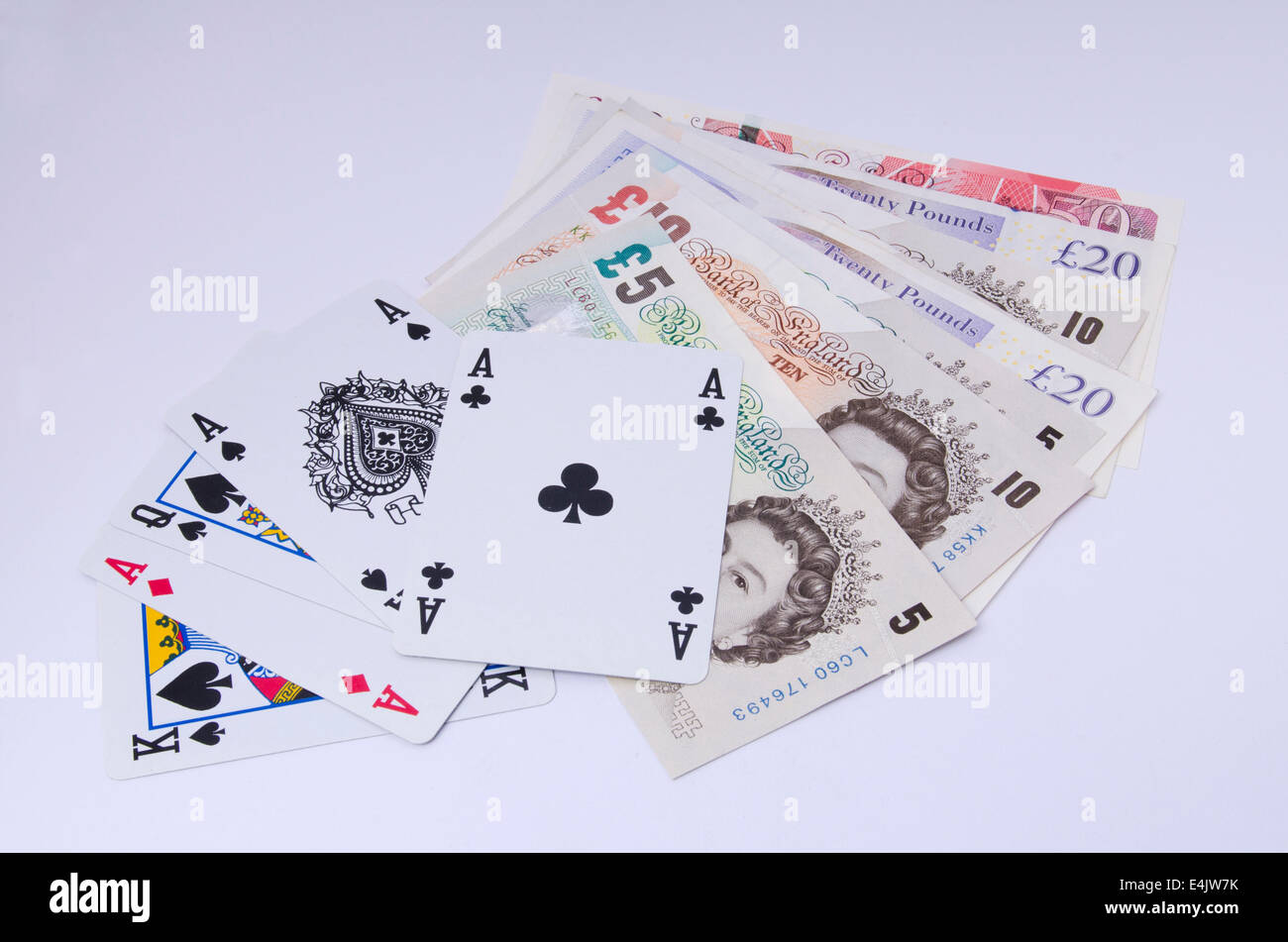 Sterline inglesi note con le carte da gioco su sfondo bianco Foto Stock