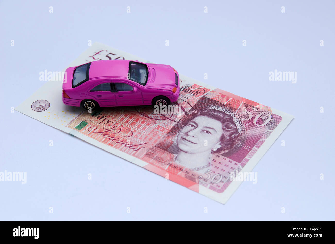 Rosa giocattolo auto su cinquanta pound nota su sfondo bianco Foto Stock