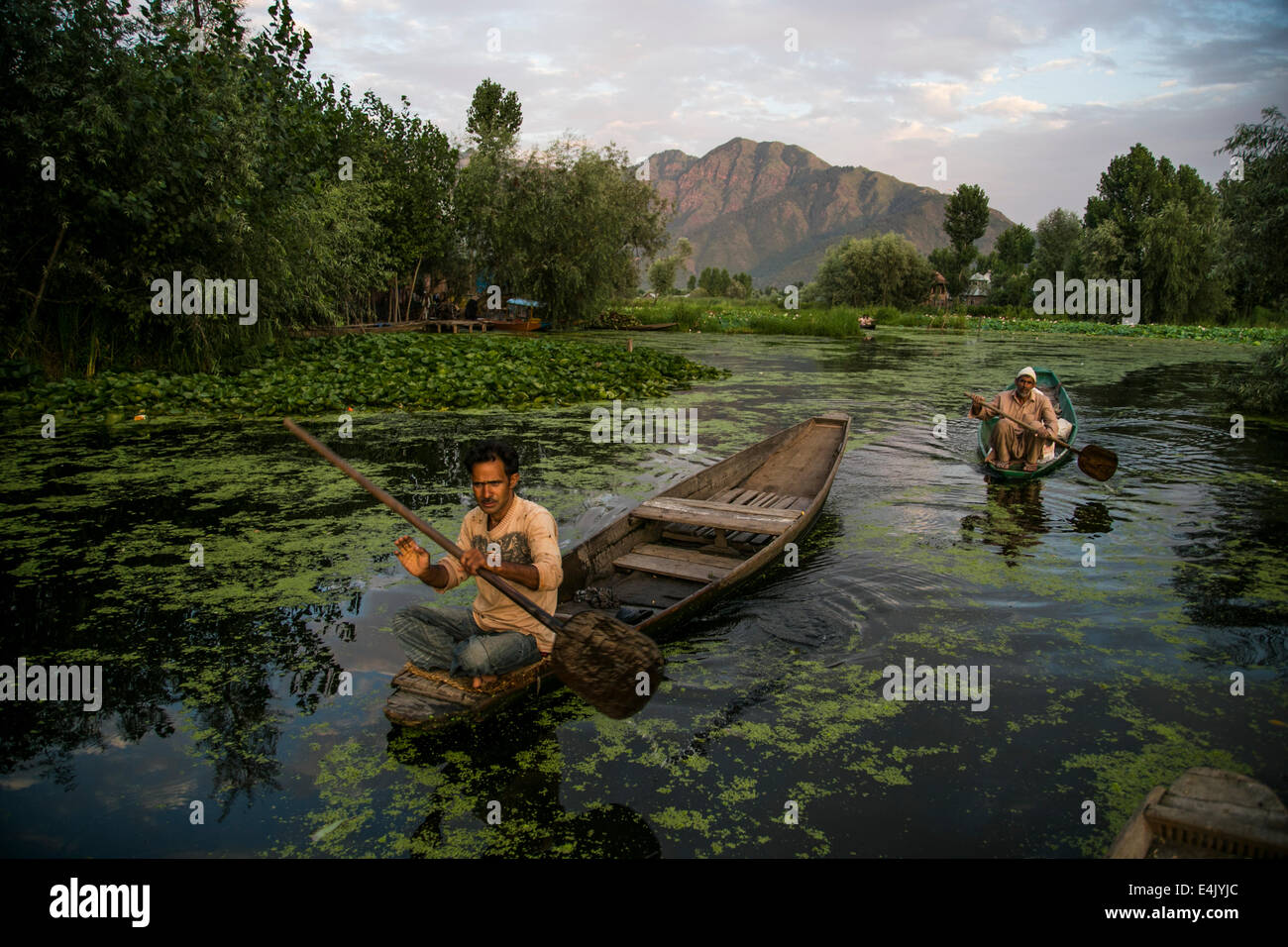 Gli uomini su una barca dal lago in Srinagar Foto Stock