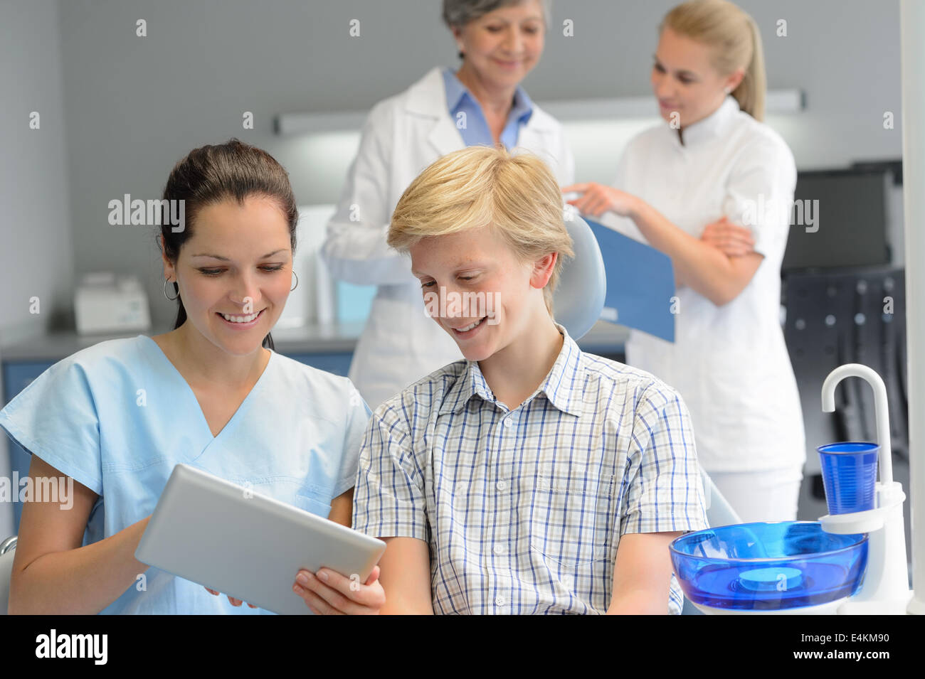 Adolescente paziente con professional dentista punto del team tablet chirurgia dentale Foto Stock