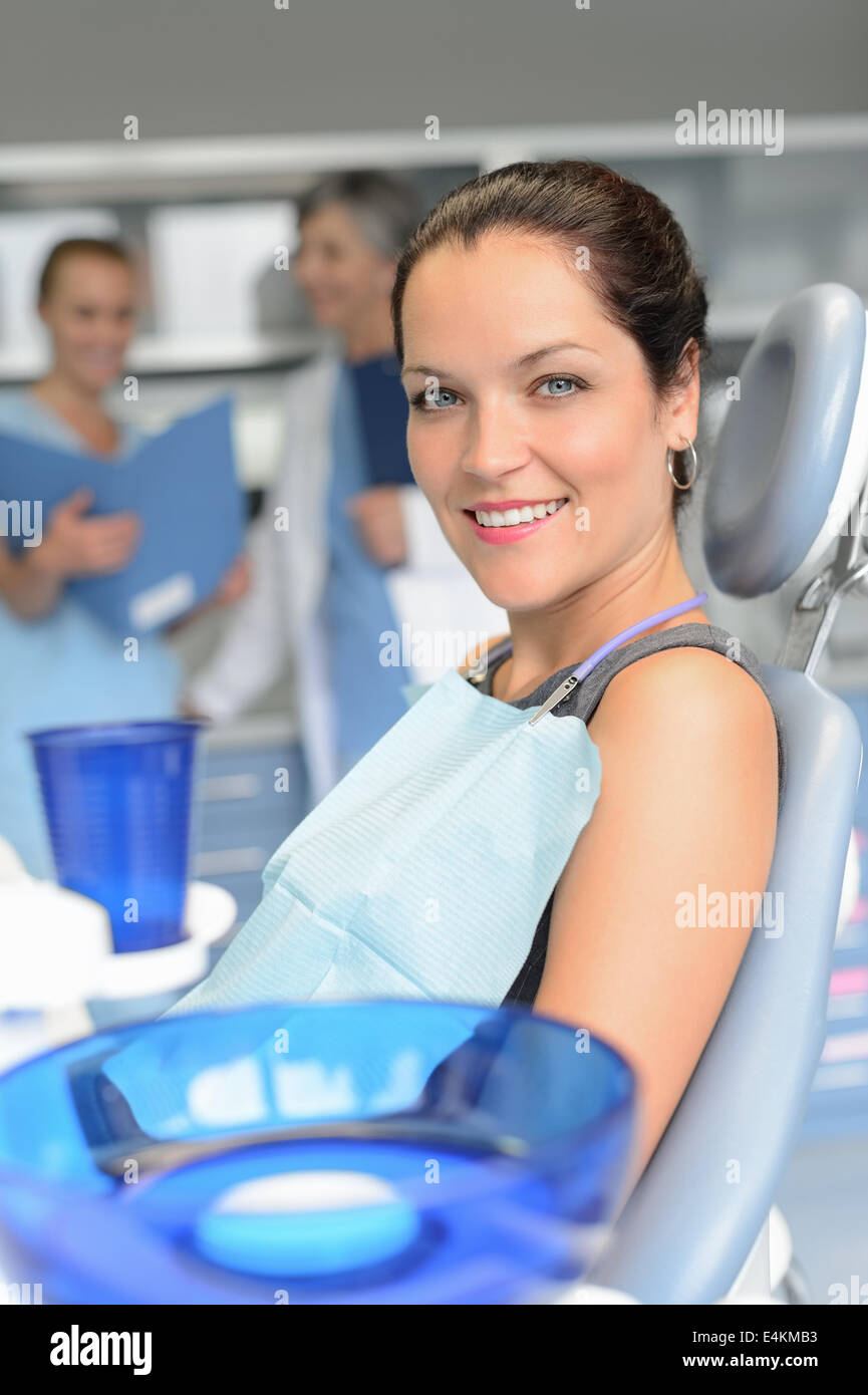 Donna seduta del paziente cattedra di chirurgia dentale professionale team di dentista checkup Foto Stock