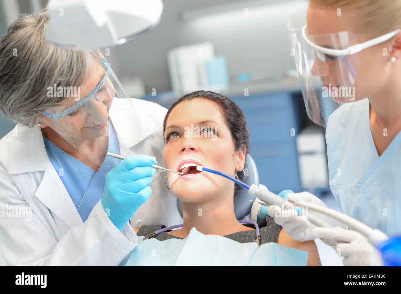 Donna dentale del paziente verificare a bocca aperta professionale team di dentista Foto Stock