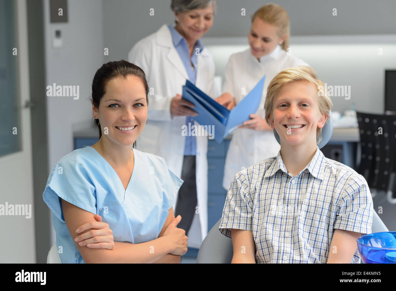 Il team odontoiatrico in odontostomatologia clinica con paziente adolescente Ragazzo che sorride Foto Stock