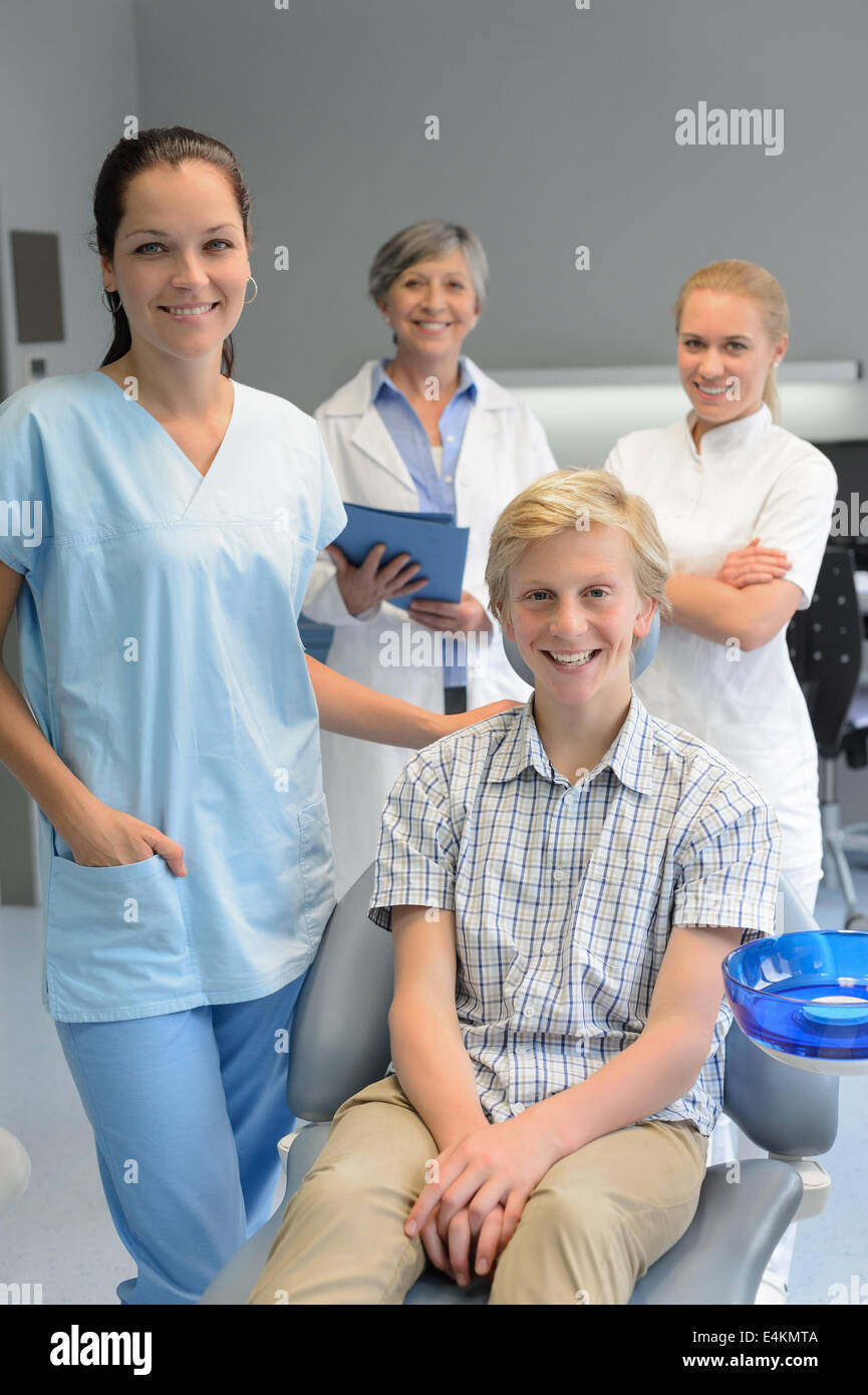 Team di dentisti con adolescente ragazzo paziente a un intervento di chirurgia dentale Foto Stock