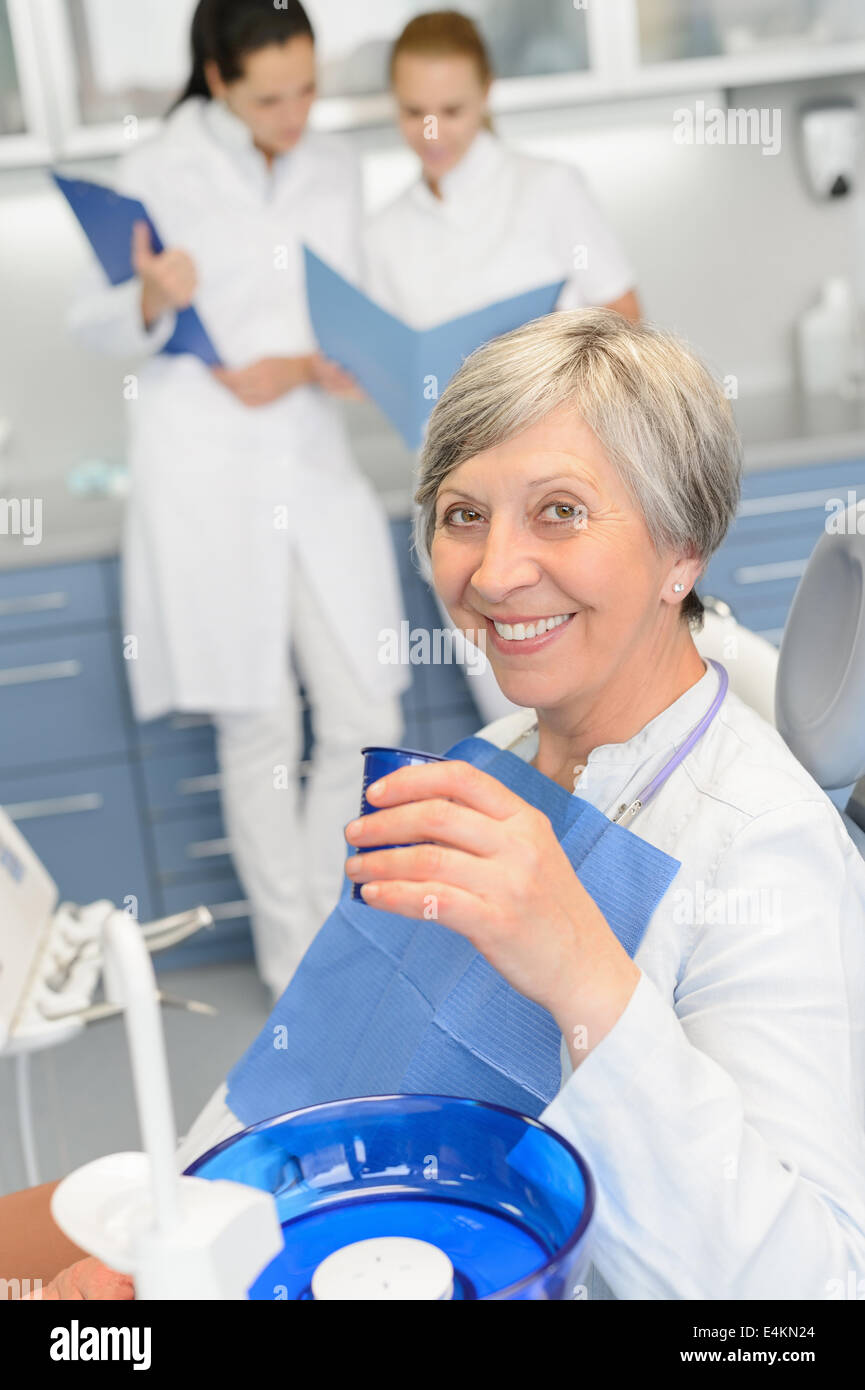 Donna anziana paziente team dentista seduta a un intervento di chirurgia dentale Foto Stock