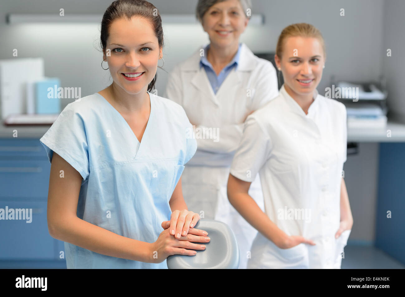 Tre dentista donna team a un intervento di chirurgia dentale cercando ritratto della fotocamera Foto Stock