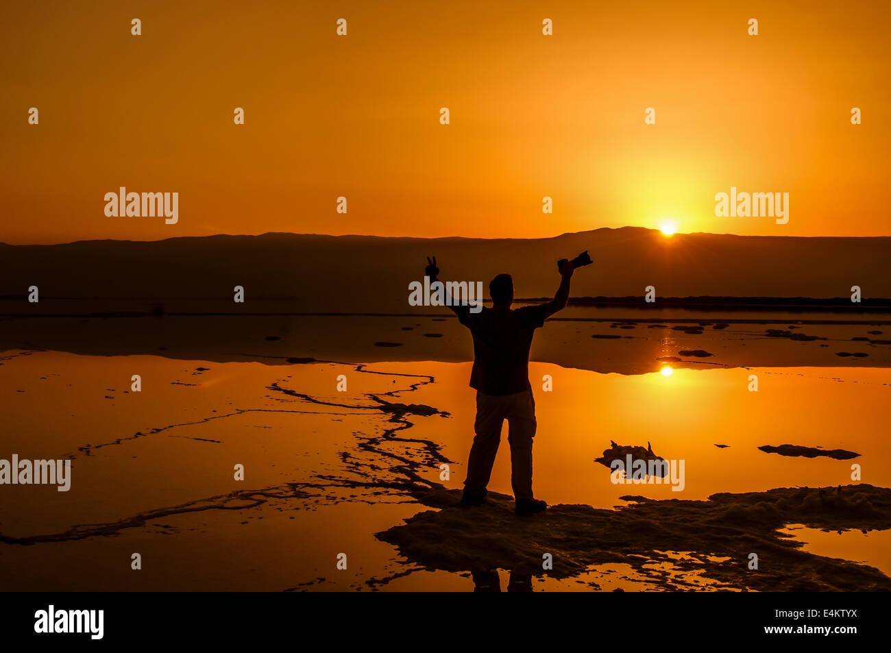 Silhouette di un uomo apprezzando il sunrise fotografato presso il Mar Morto Israele Foto Stock