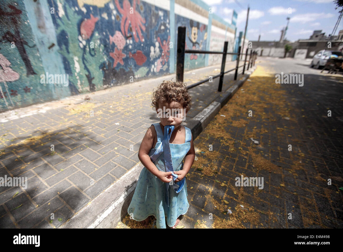 La striscia di Gaza, Territori palestinesi. 13 Luglio, 2014. Una ragazza palestinese per le strade di Gaza, il 13 luglio 2014. Marines israeliani montato un primo attacco di terra su Gaza, ulteriore escalation di un letale sei giorni di offensiva ore dopo il Consiglio di Sicurezza delle Nazioni Unite ha chiesto unanimemente per un cessate il fuoco. Credito: Momen Faiz/NurPhoto/ZUMA filo/Alamy Live News Foto Stock