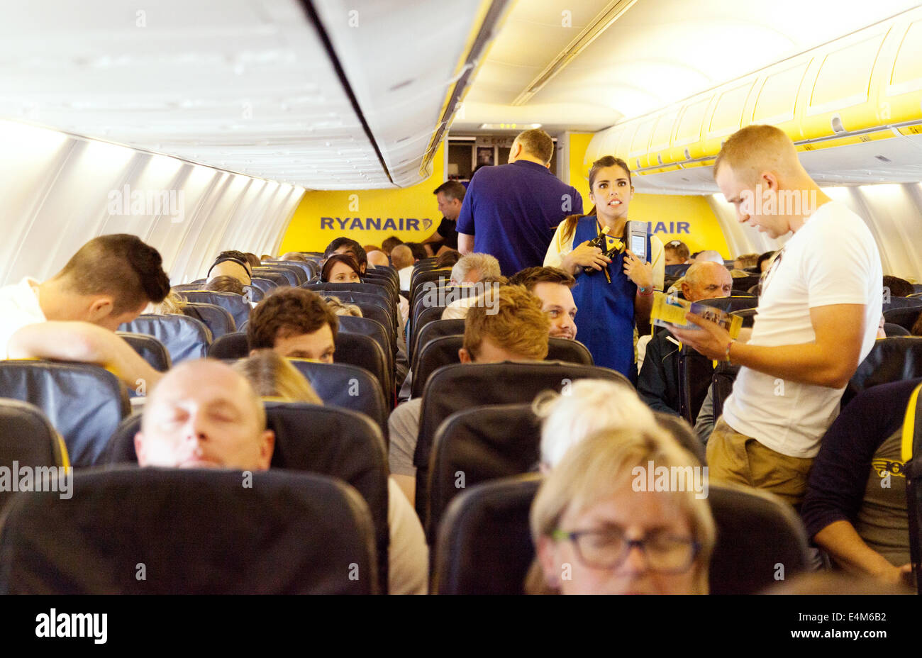 I passeggeri e il personale nel piano cabina Ryanair, la compagnia aerea a basso costo Foto Stock