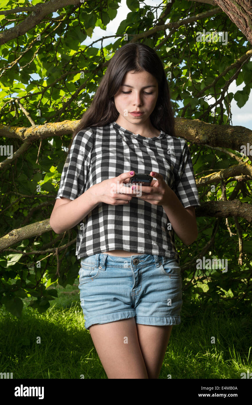 Ragazza adolescente texting sul suo telefono cellulare Foto Stock