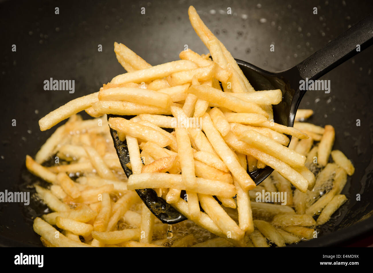 Le patatine fritte in una padella calda. Foto Stock