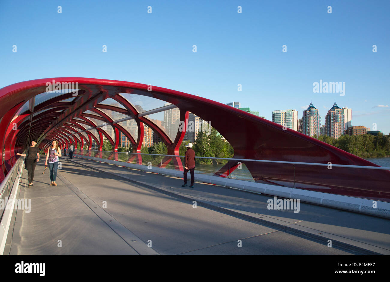Pedoni che attraversano il ponte di pace che collega Sunnyside a nord del Fiume Bow con Eau Claire sul lato sud. Foto Stock