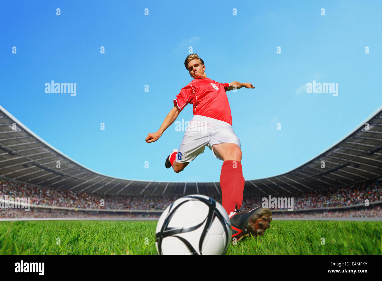Giocatore di calcio calciare la palla Foto Stock