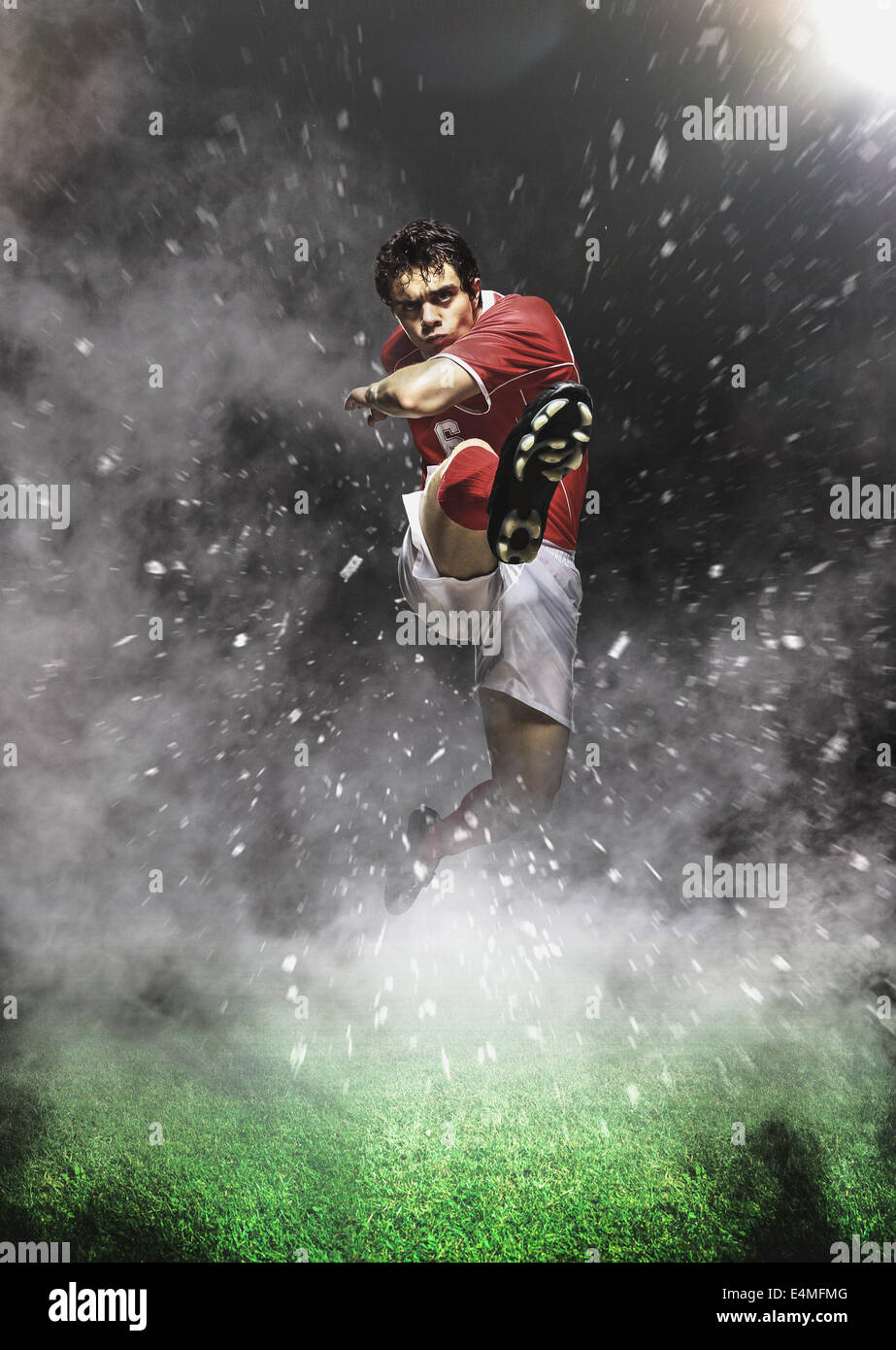 Giocatore di calcio calci In Mid-Air Foto Stock