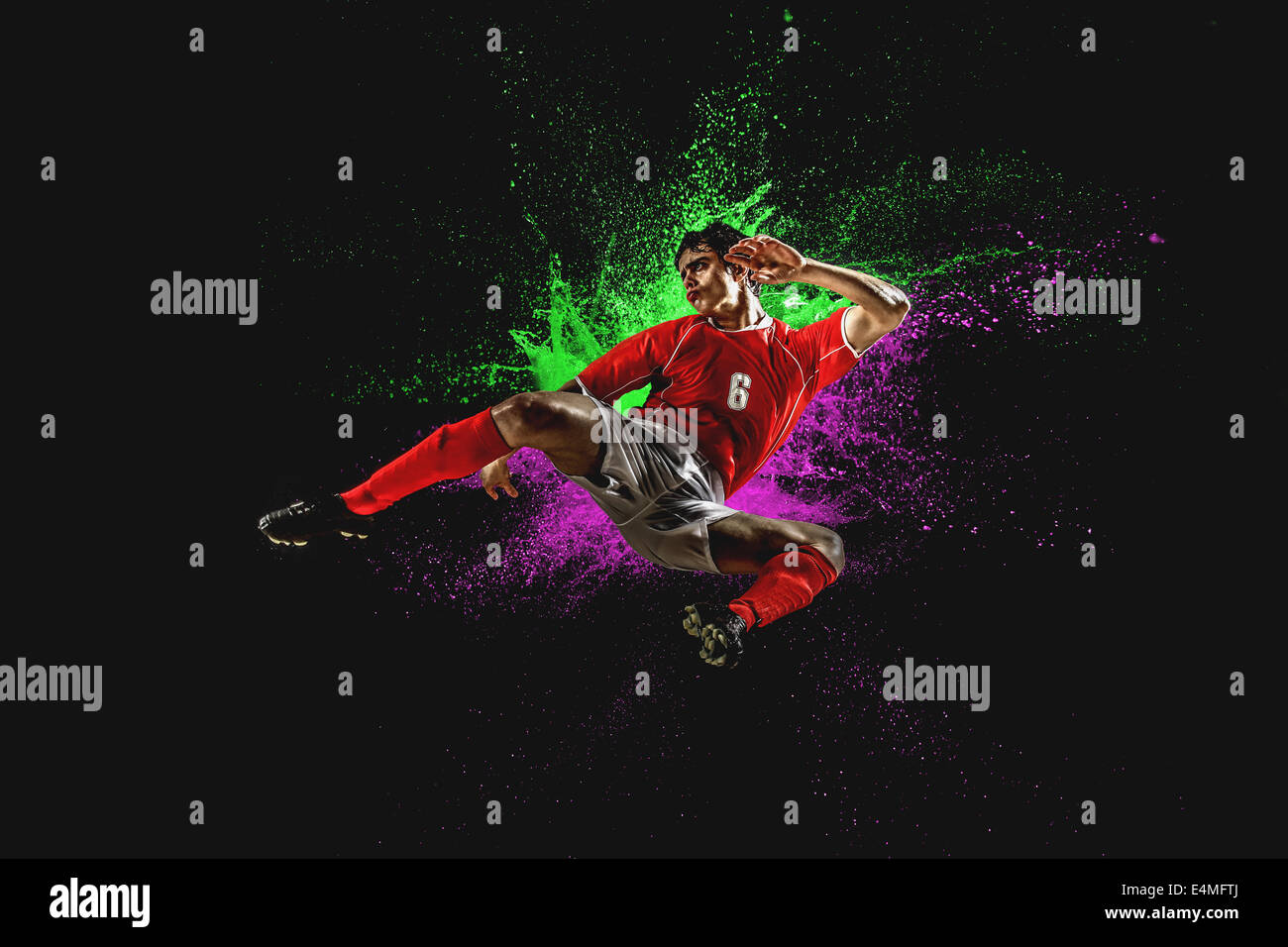 Giocatore di calcio calci In Mid-Air Foto Stock Giocatore di calcio calci In Mid-Air Foto Stock