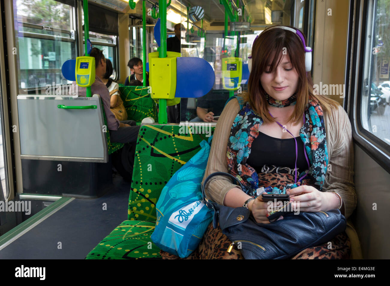 Melbourne Australia,tram Yarra,tram,tram,tram,tram,passeggeri passeggeri riders,ciclista,donna donna donna,vestita bene,attraente,cuffie,sit Foto Stock