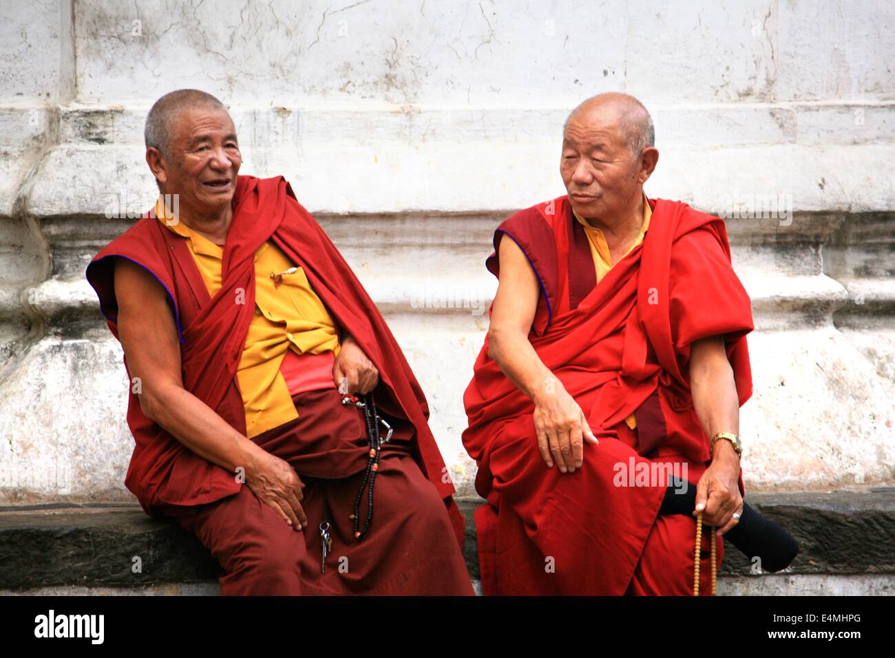 Monaci buddisti tibetani chat e ridere a un tempio a Kathmandu in Nepal Foto Stock