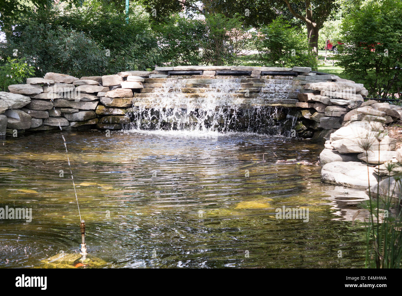 L'uomo ha fatto una piccola cascata circondata da rocce con sprinkler in Victoria Park di Lindsay, Ontario Canada Foto Stock