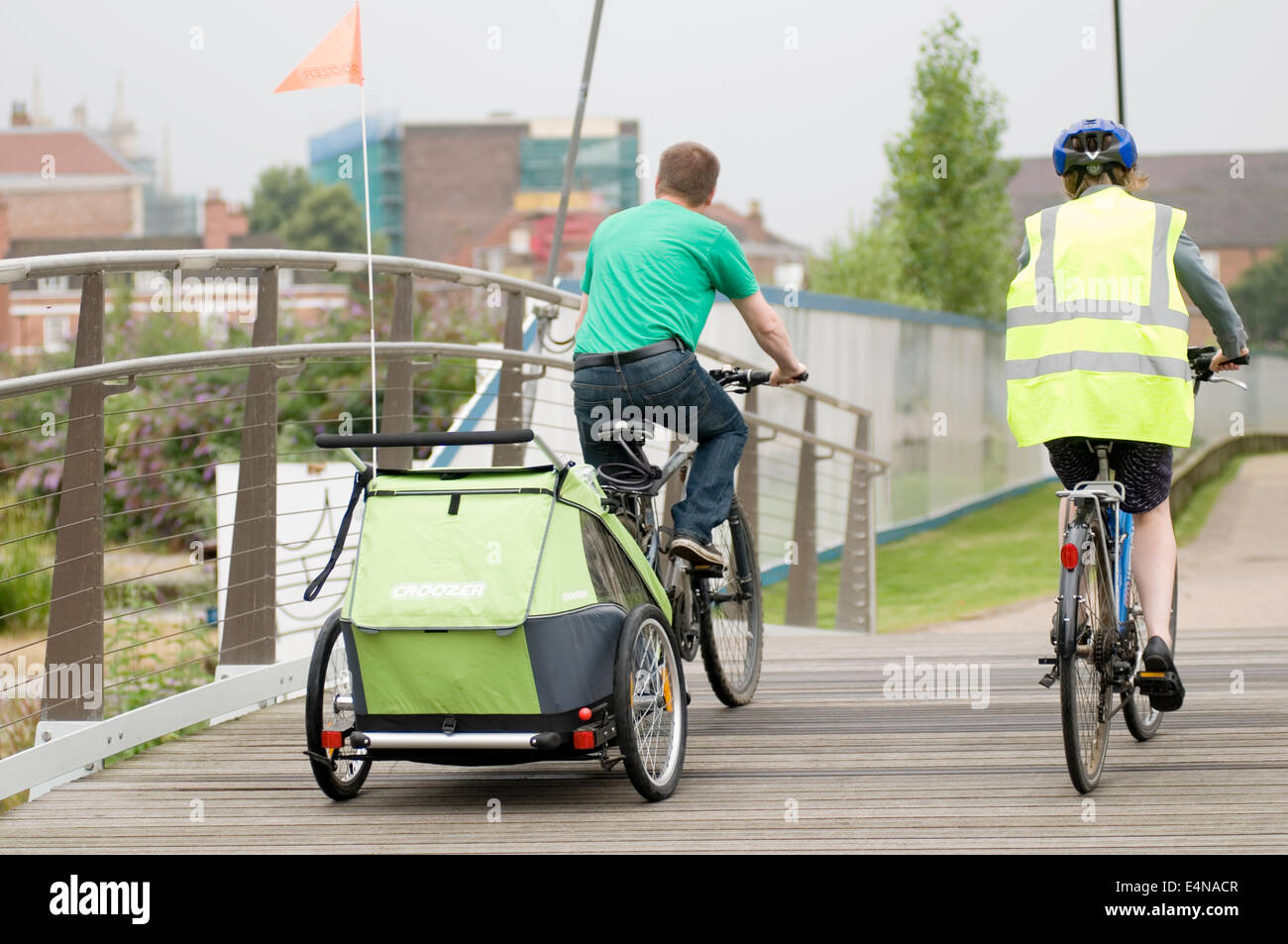 Indossando una elevata visibilità vis jacket vest lane ciclo corsie a York Regno Unito buggy trainare rimorchi kid kids bambini su in bambini doubl Foto Stock