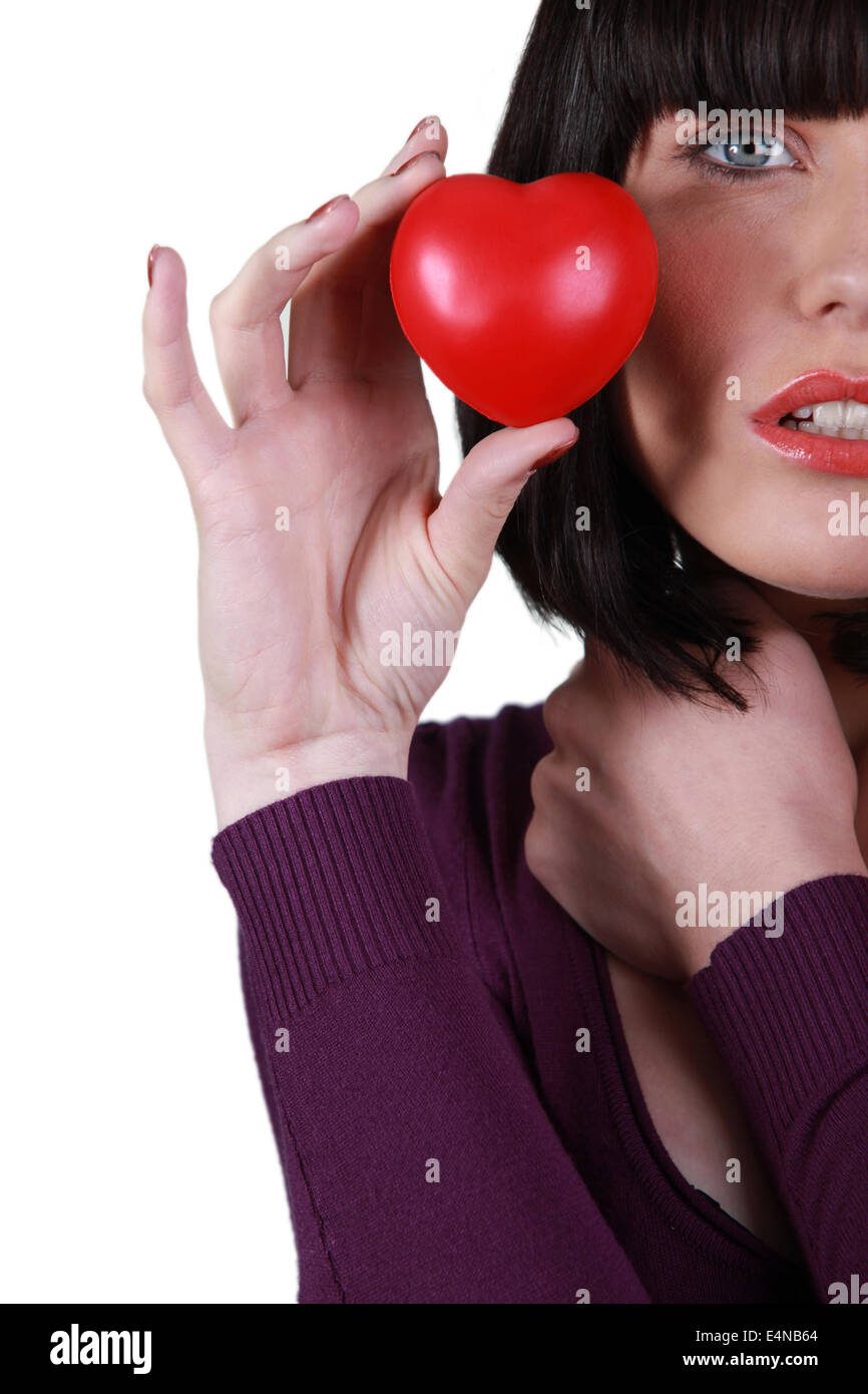 Giovane donna in possesso di un po' di cuore rosso Foto Stock