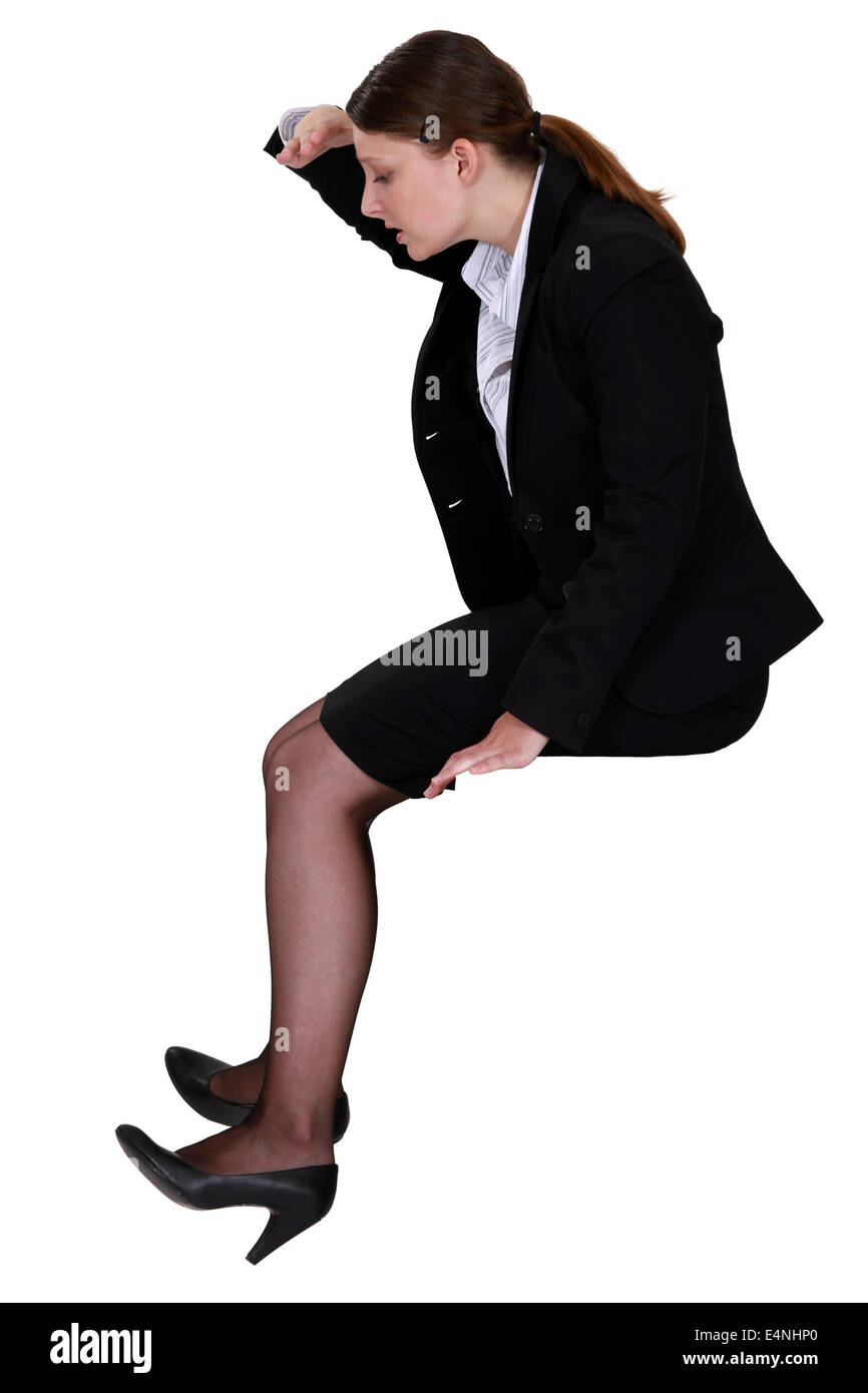Donna seduta guardando verso il basso Foto Stock