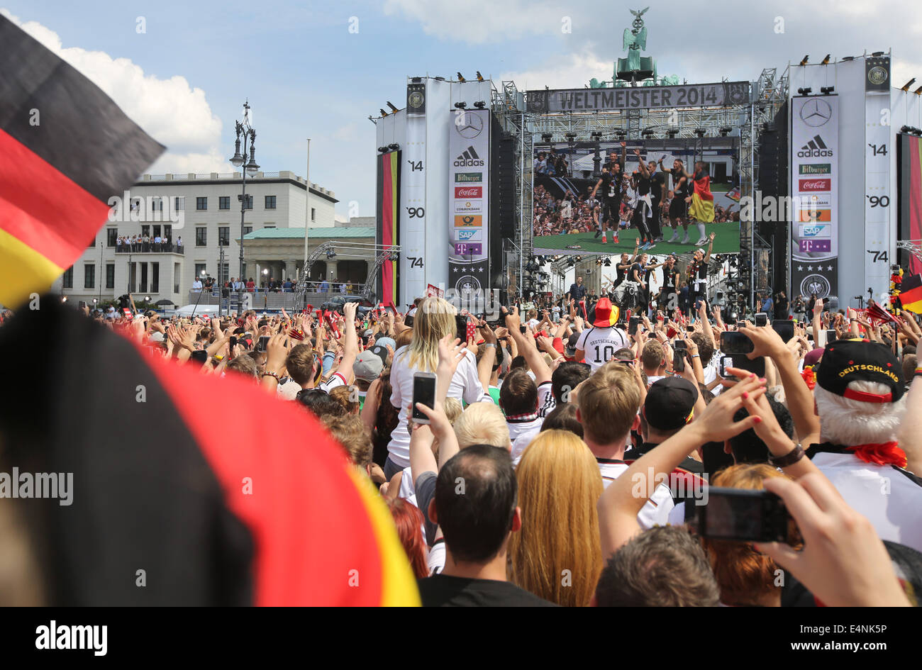 Berlino, Germania. Il 15 luglio 2014. Ventole allietare e celebrare durante il ricevimento di benvenuto per la Germania la nazionale di calcio di fronte alla Porta di Brandeburgo, Berlino, Germania, 15 luglio 2014. Il team tedesco ha vinto il Brasile 2014 FIFA Soccer finale di Coppa del Mondo contro l'Argentina da 1-0 il 13 luglio 2014, vincendo il titolo di coppa del mondo per la quarta volta dopo il 1954, 1974 e 1990. Foto: Michael Kappeler/dpa/Alamy Live News Foto Stock