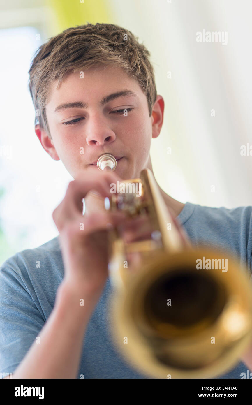 Ragazzo adolescente (16-17) suonare la tromba Foto Stock