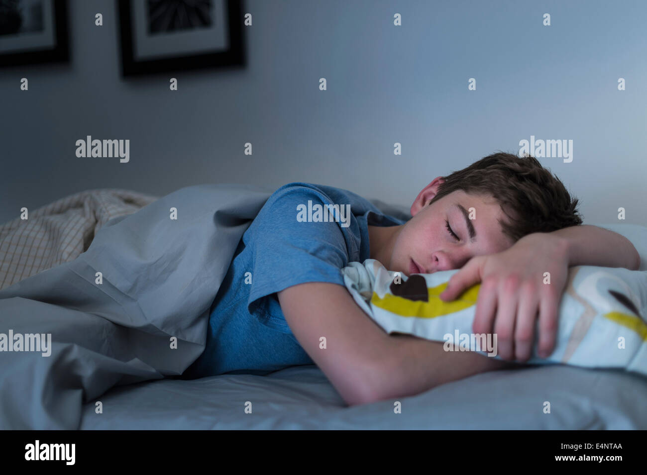 Ragazzo adolescente (16-17) dormire nel letto Foto Stock