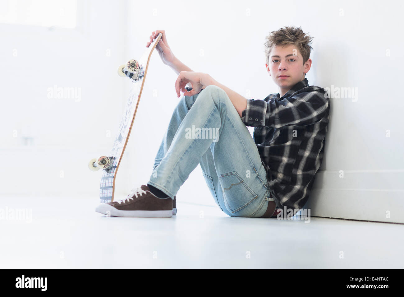 Ragazzo adolescente (16-17) azienda skateboard Foto Stock