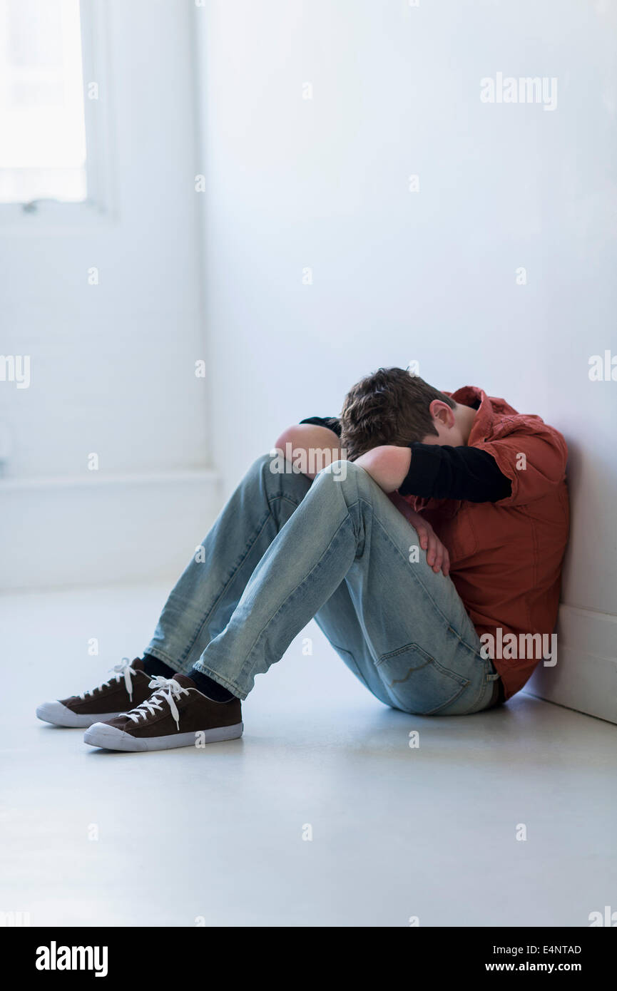 Ragazzo adolescente (16-17) seduto in corridoio Foto Stock