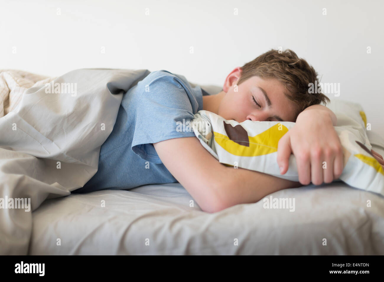 Ragazzo adolescente (16-17) dormire nel letto Foto stock - Alamy