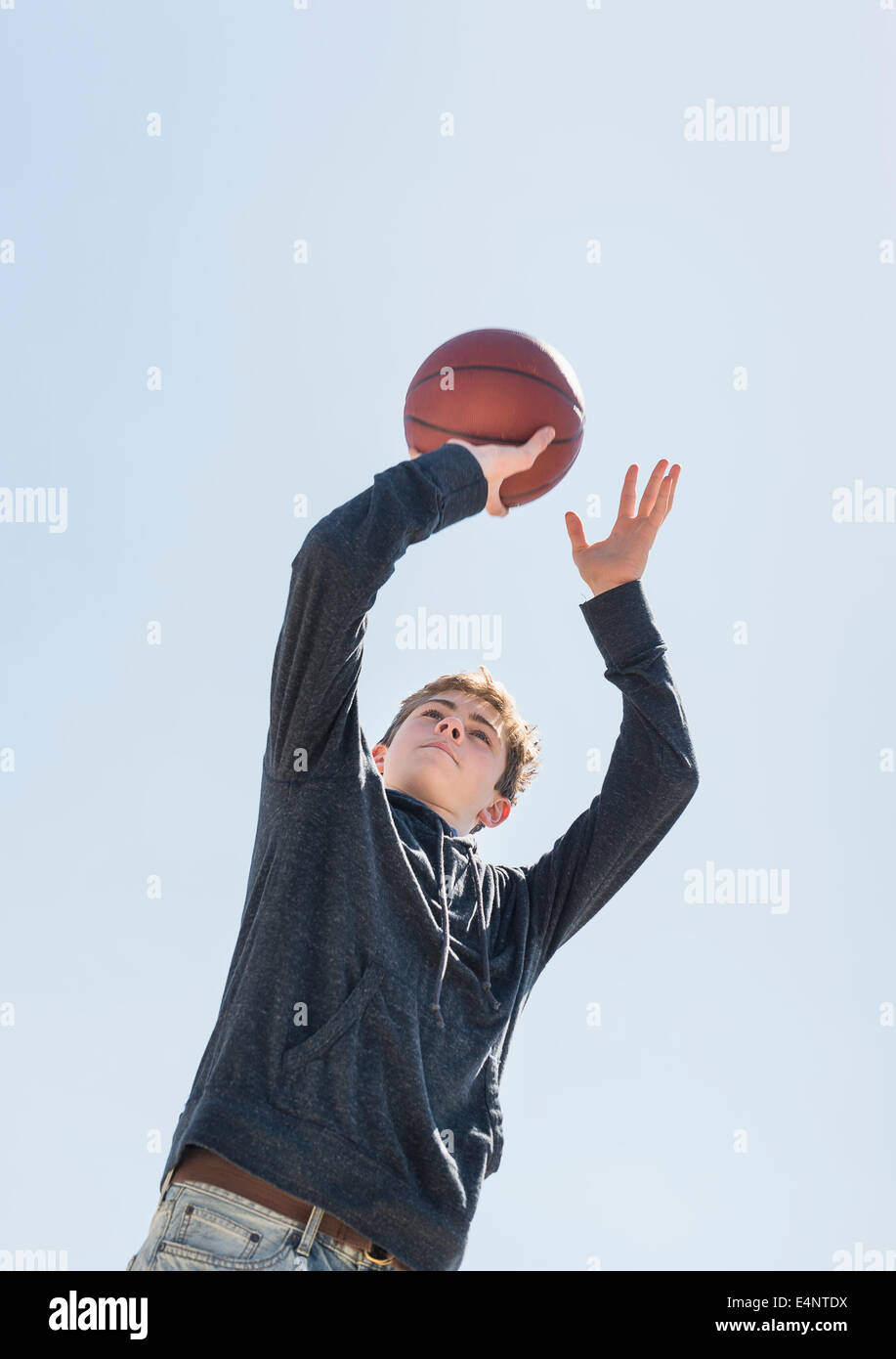 Ragazzo adolescente (16-17) giocare a basket Foto Stock