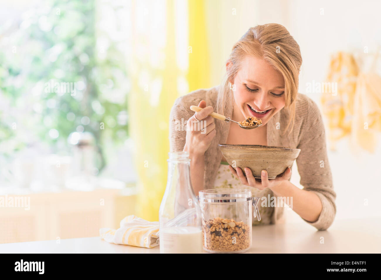 Giovane donna di mangiare cereali per la prima colazione Foto Stock