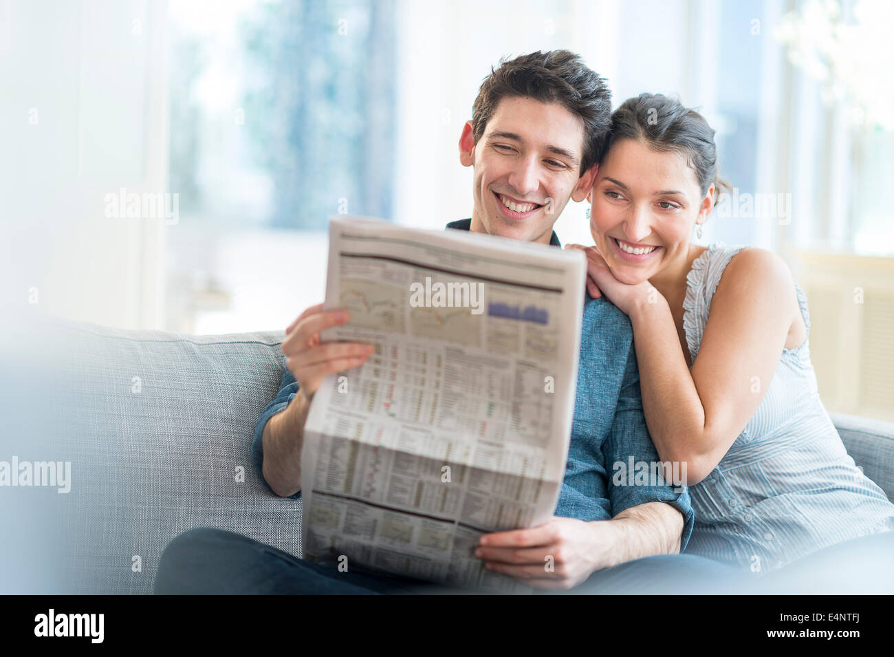 Accoppiare la lettura di giornale sul divano Foto Stock