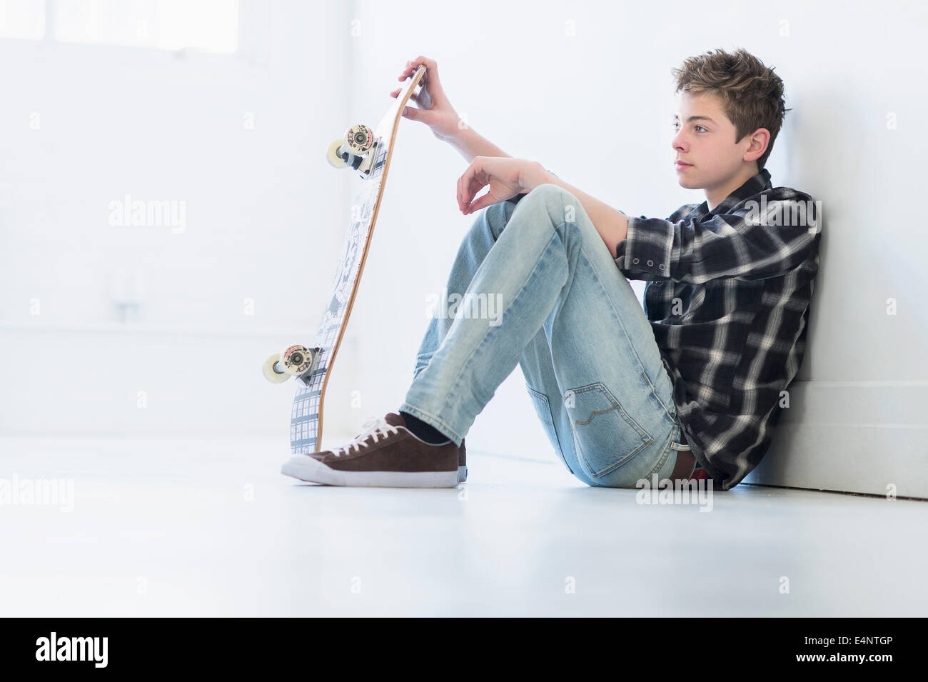 Ragazzo adolescente (16-17) azienda skateboard Foto Stock