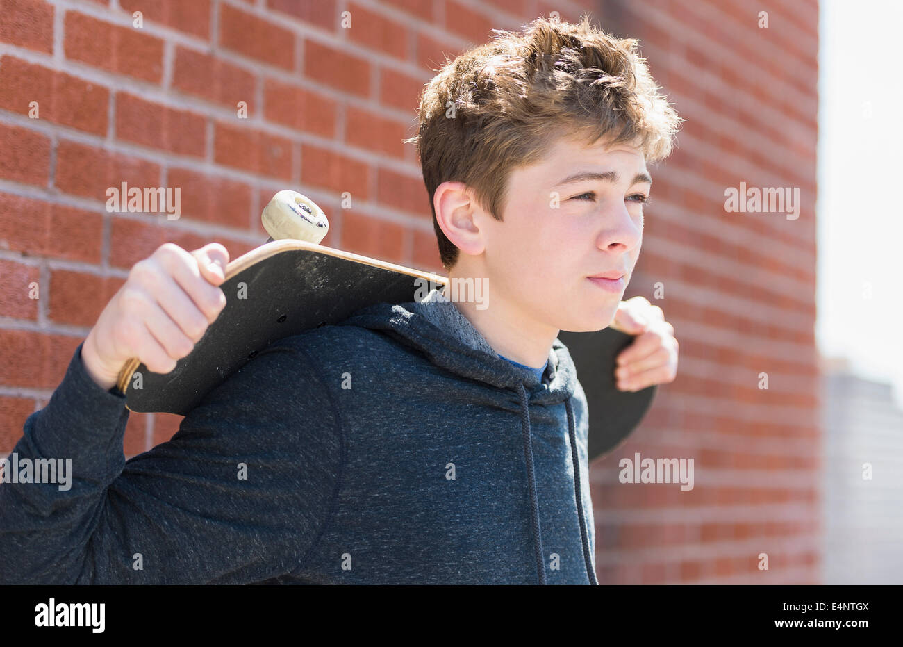 Ragazzo adolescente (16-17) azienda skateboard Foto Stock