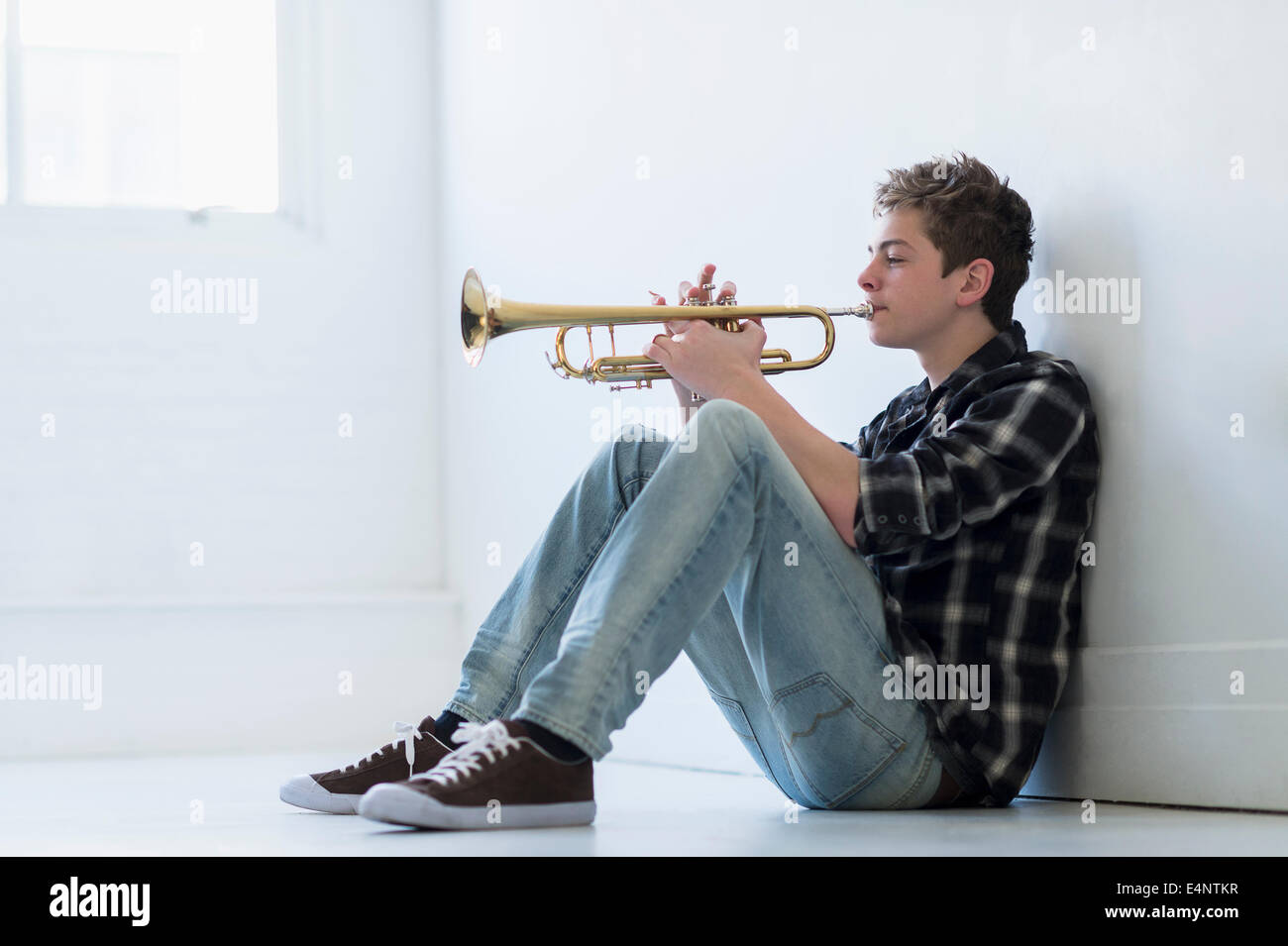 Ragazzo adolescente (16-17) suonare la tromba in corridoio Foto Stock