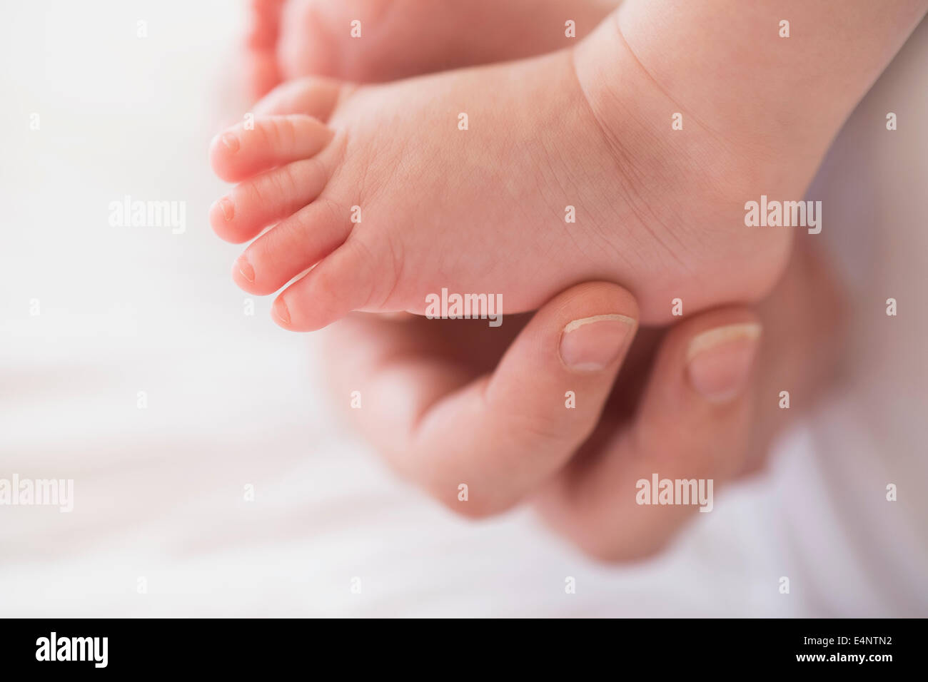 Close up di madre la mano toccare baby boy (2-5 mesi) a piedi Foto Stock
