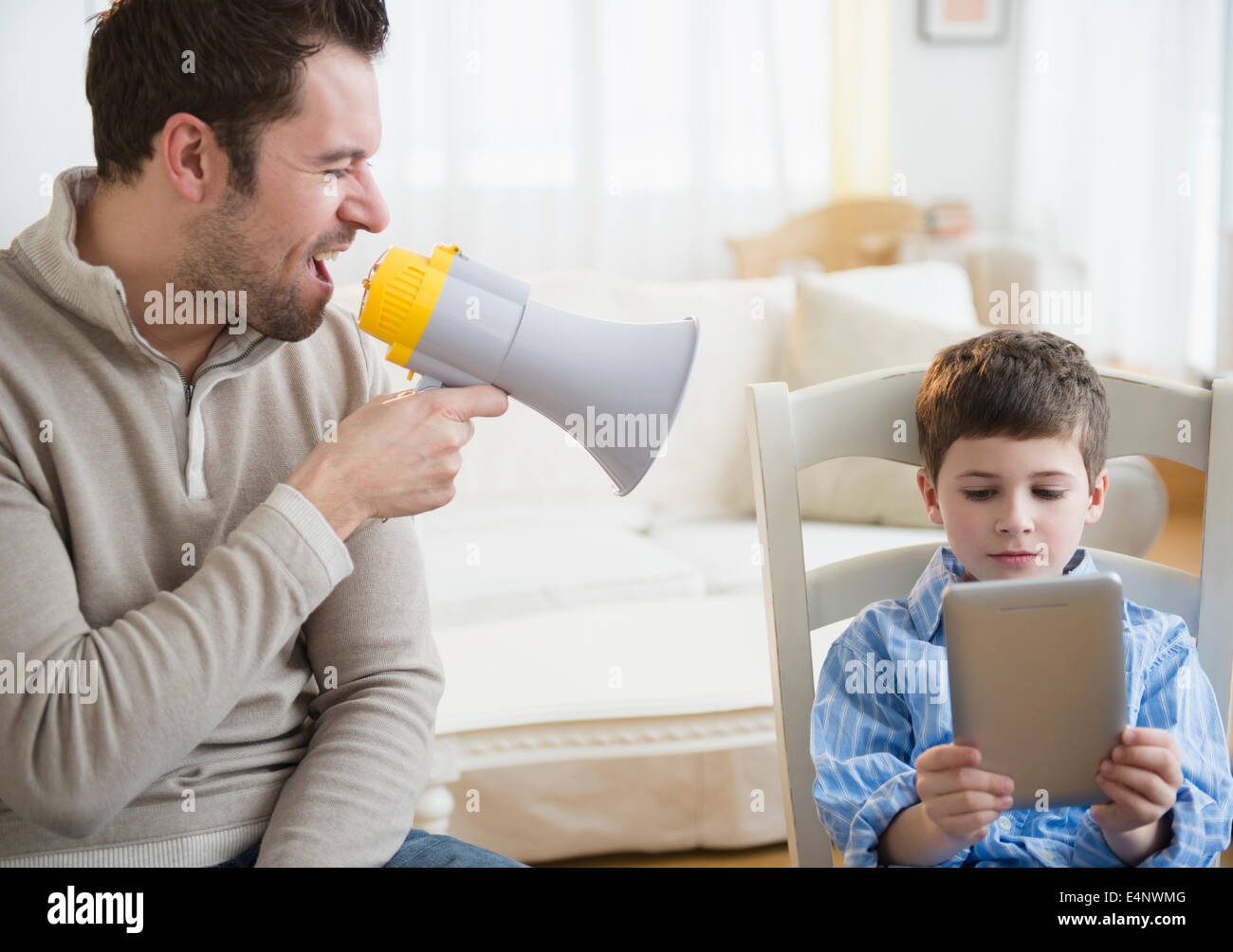 Padre urlando nel megafono per la disciplina del figlio (8-9) Foto Stock