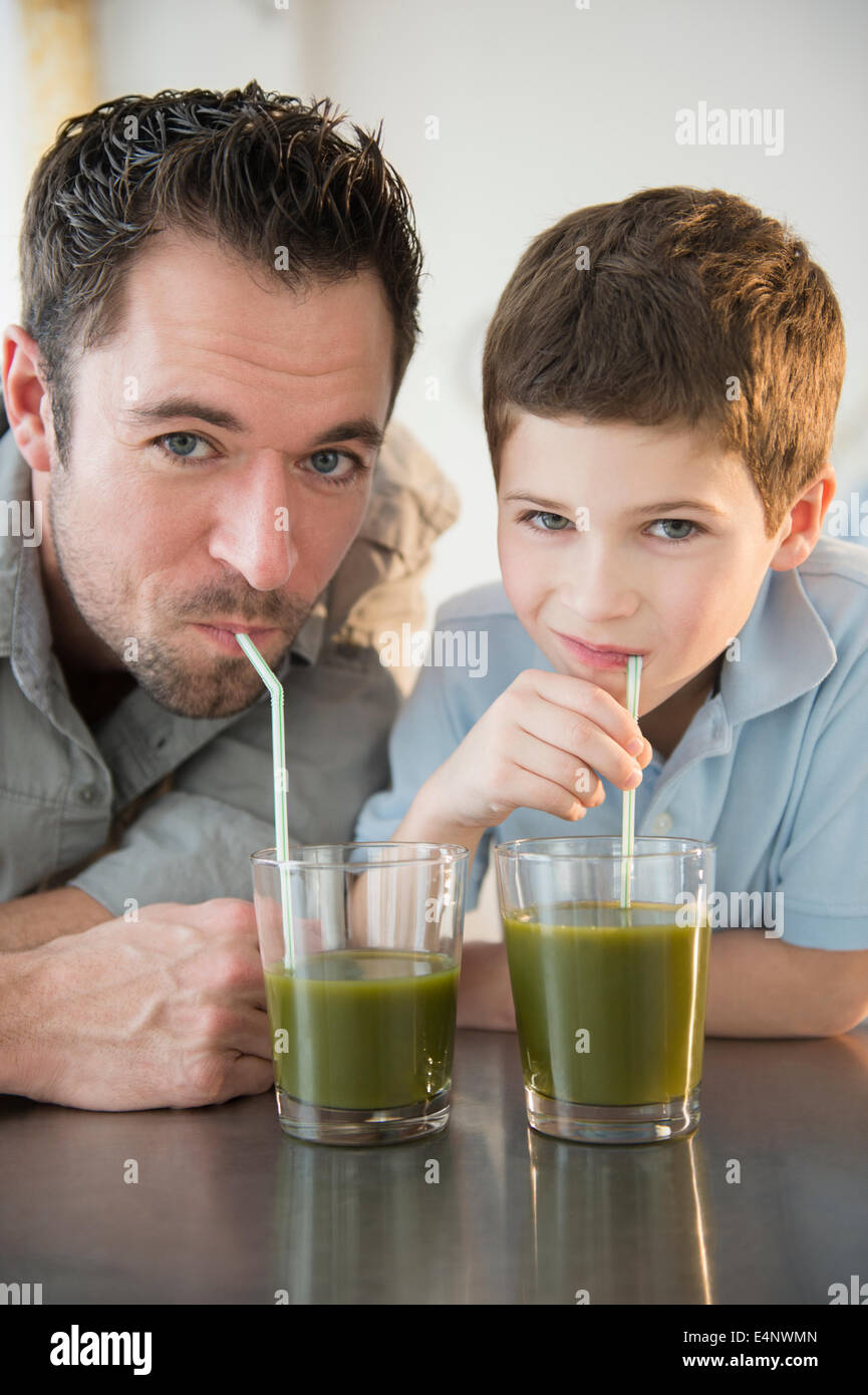 Padre e figlio (8-9) di bere succo di frutta Foto Stock