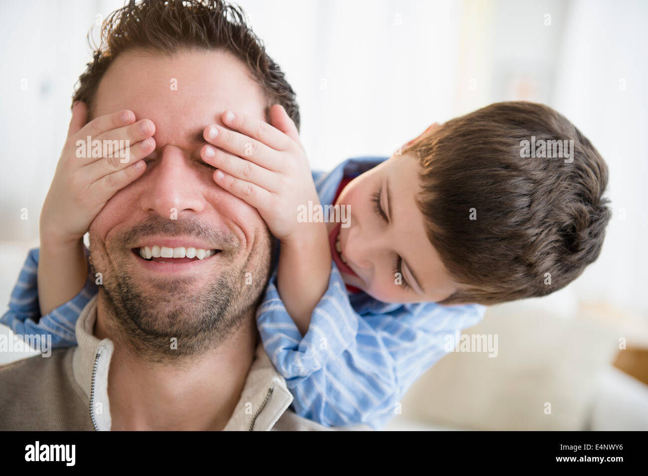Figlio (8-9) copertura padre agli occhi Foto Stock