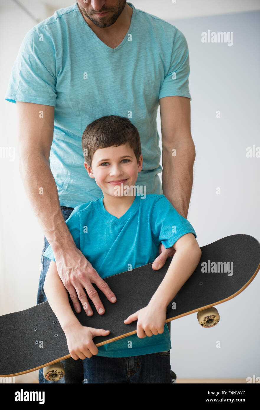 Padre e figlio (8-9) azienda skateboard Foto Stock
