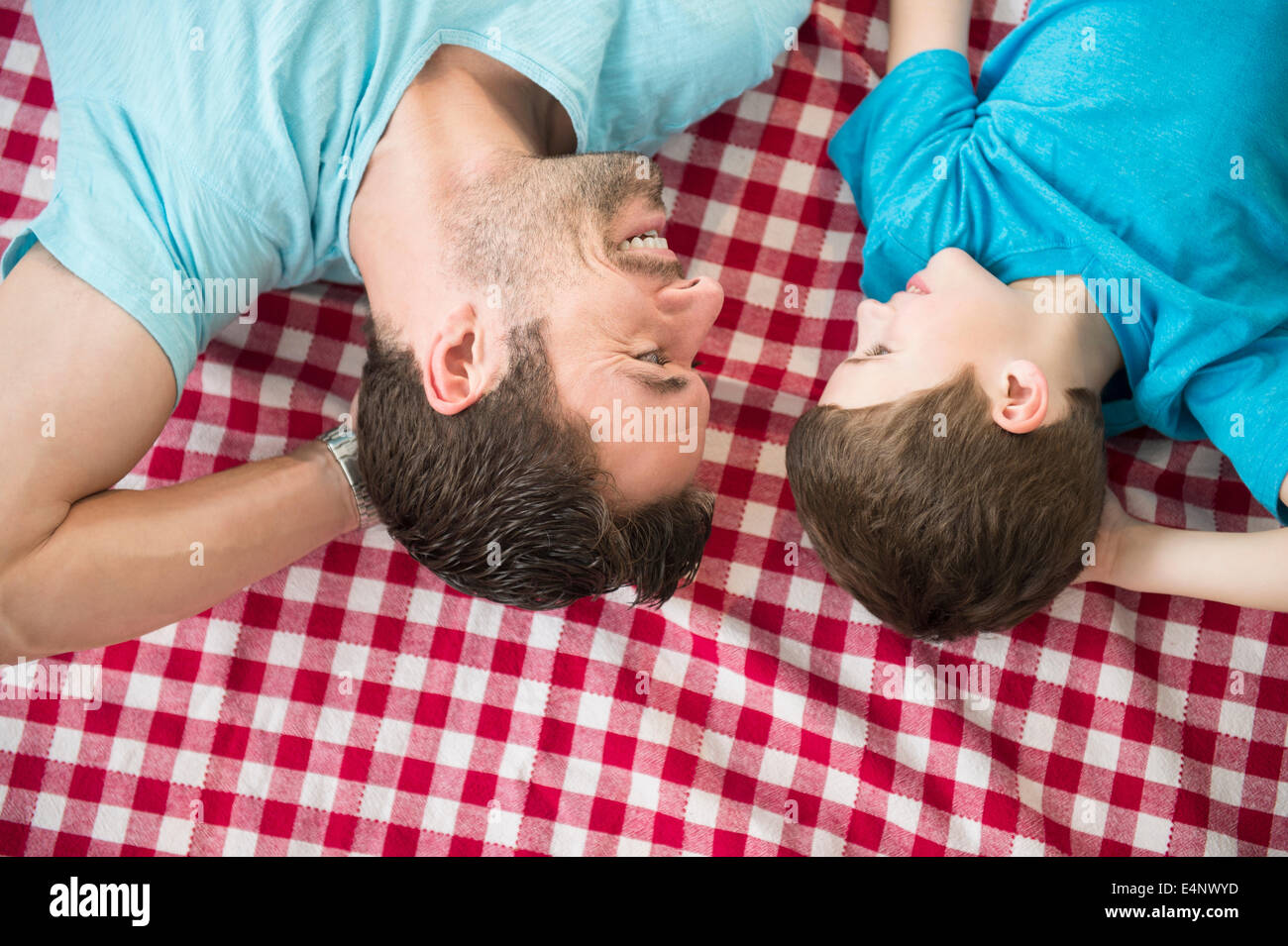 Padre e figlio (8-9) rilassante sulla verifica copertura Foto Stock